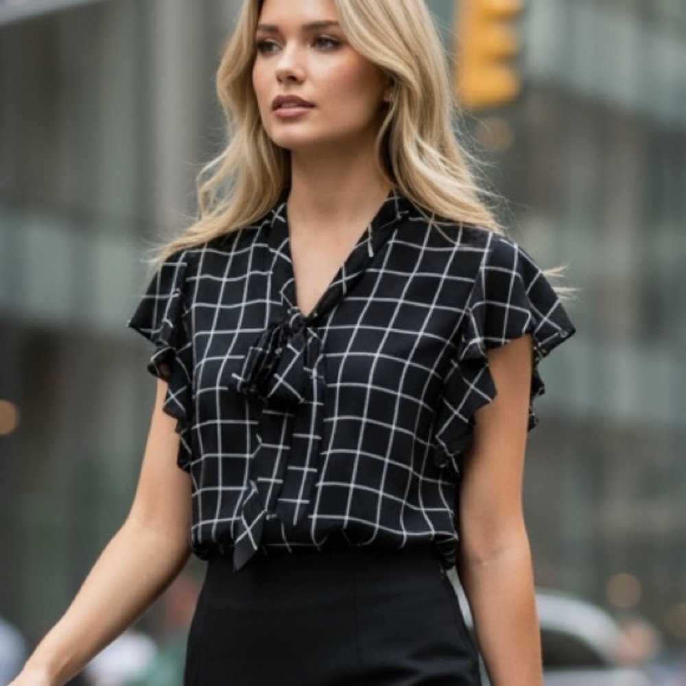 Black/white flowy sleeveless blouse with v-neck tie and‎ flutter armholes.
